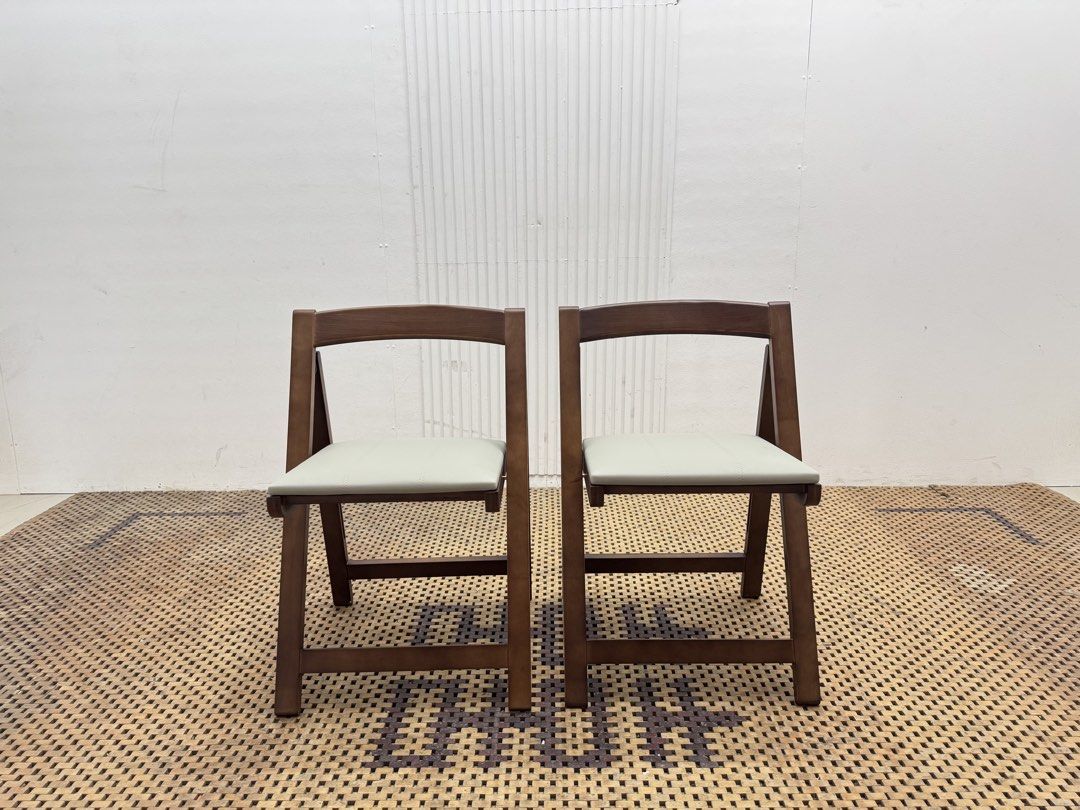 Folding chair (Category: Chairs) located in Quezon City. Submitted by matetdevis13 (Listing ID 1468231123, Image 1). Description: NEW! VIVI CASA Set of 2 Brown Wooden Folding Dining Chairs with Cream Cushioned Seats Price: 4,900 L17.5 x W18 x H27/17.5 Brand New with box Code JMD15-M117A They feature a warm brown wooden frame, cream padded seats, curved backrests, and a foldable design for easy storage..