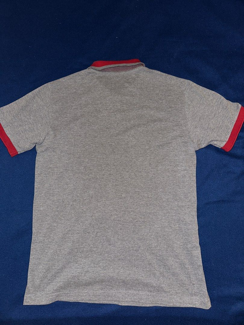 Fred Perry polo shirt L (Category: Tshirts & Polo Shirts ) located in Quezon City. Submitted by mancave_stuff (Listing ID 1468165311, Image 2). Description: • Brand: Fred Perry • Size: L (Large) W19” x L27” • Color: Heather Grey / Red • Origin: Made in Portugal • Material: Premium piqué cotton (breathable and high-quality knit) • Design Elements: Contrast red collar tipping, custom Fred Perry branded buttons, and classic Laurel Wreath embroidery.