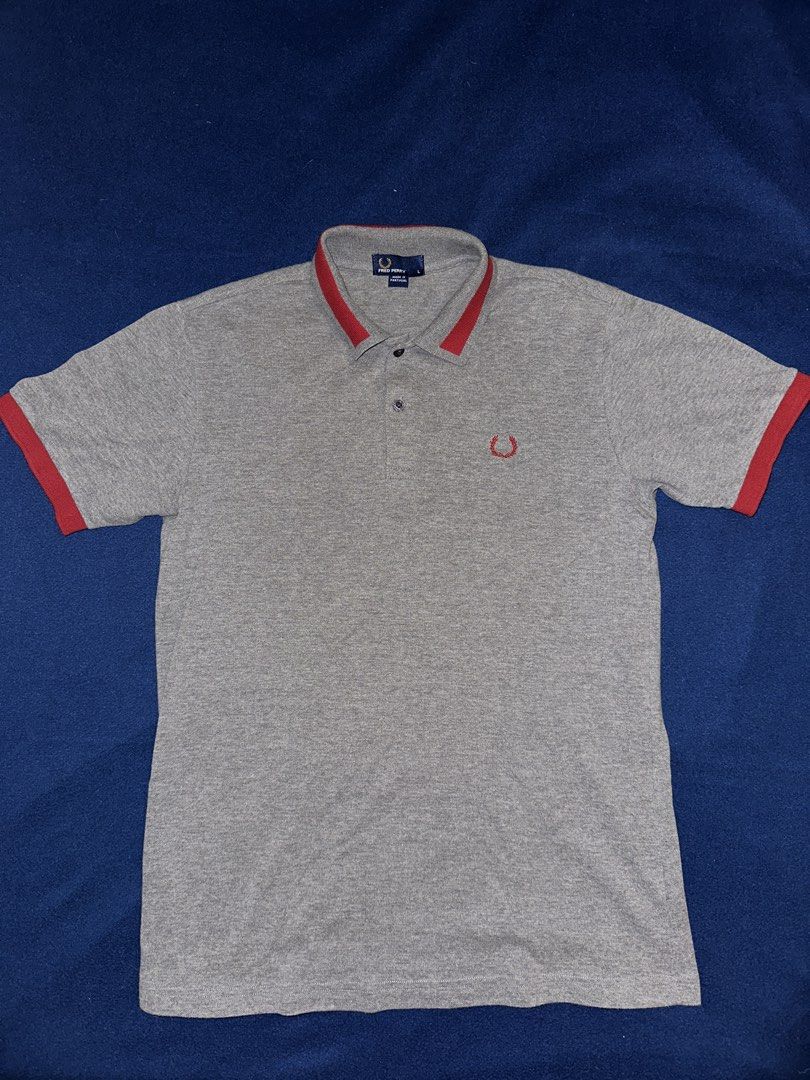 Fred Perry polo shirt L (Category: Tshirts & Polo Shirts ) located in Quezon City. Submitted by mancave_stuff (Listing ID 1468165311, Image 1). Description: • Brand: Fred Perry • Size: L (Large) W19” x L27” • Color: Heather Grey / Red • Origin: Made in Portugal • Material: Premium piqué cotton (breathable and high-quality knit) • Design Elements: Contrast red collar tipping, custom Fred Perry branded buttons, and classic Laurel Wreath embroidery.