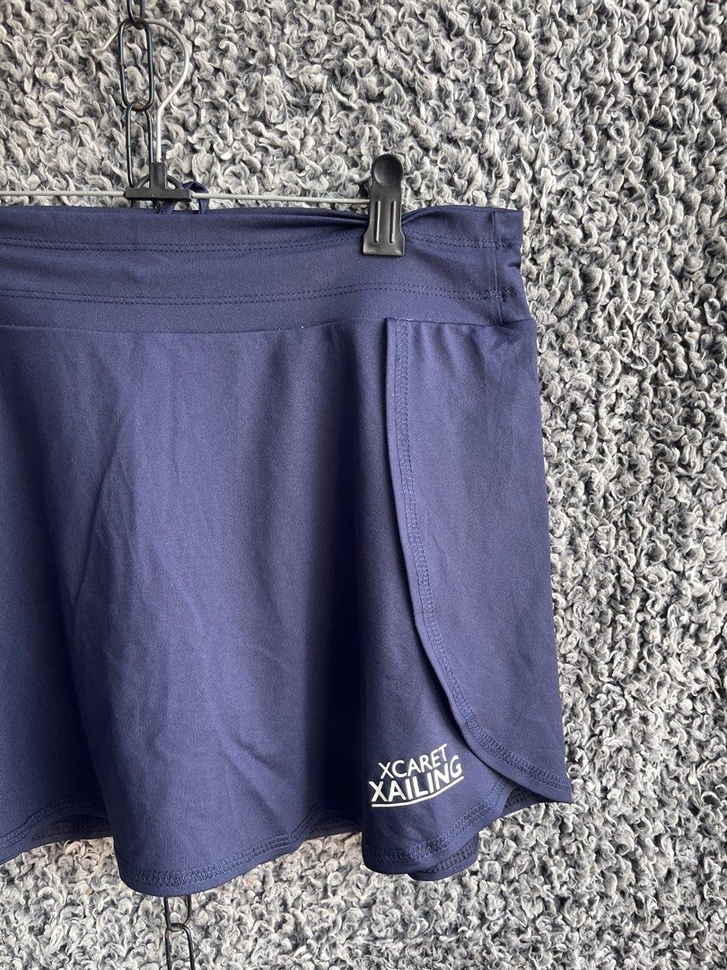 Full Sand navy blue athletic skort | Size L (Category: Skirts) located in General Trias. Submitted by zrchustle.604 (Listing ID 1468281521, Image 2). Description: Full Sand navy blue athletic skort branded with the logo for Xcaret Xailing, which is an official ferry and catamaran excursion service based in Cancun, Mexico. This garment features an overlapping faux-wrap skirt overlay with a rounded dolphin-style hem and an elastic waistband..
