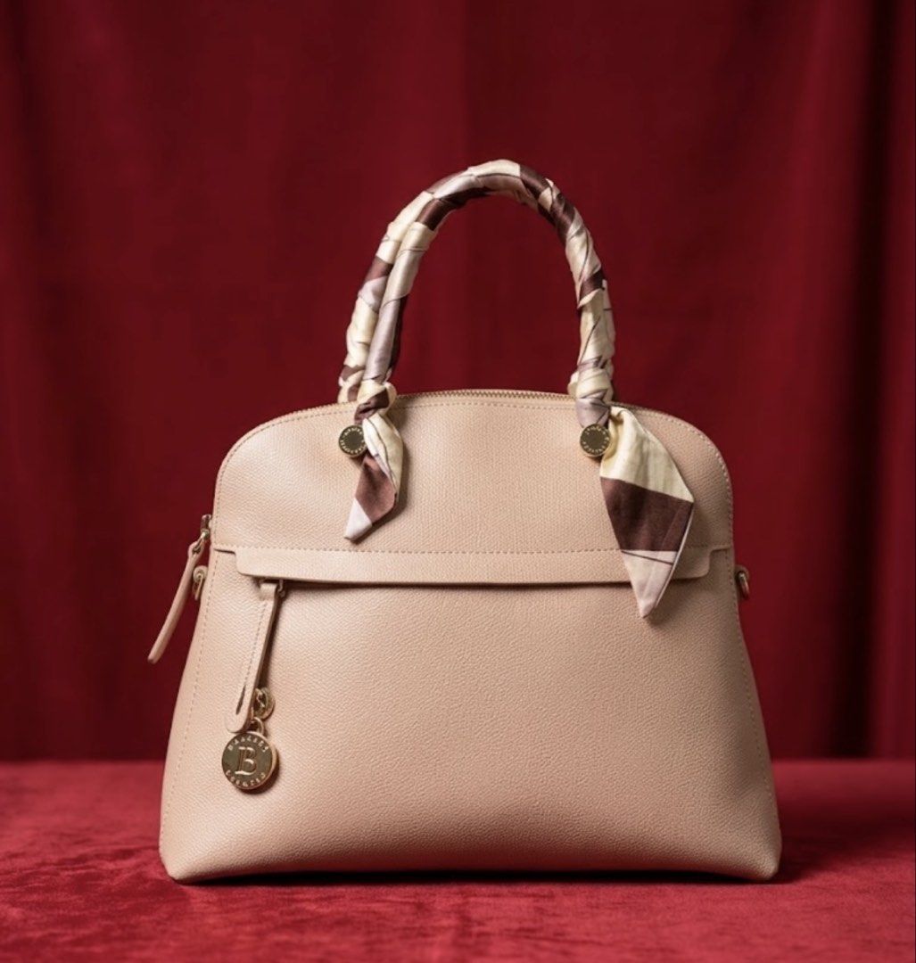 Furla Leather Handbag (Category: Luxury Bags & Wallets) located in Marikina City. Submitted by sakura_07 (Listing ID 1468125420, Image 1). Description: - Brand: Furla (100% Authentic) - Material: Premium pebbled leather - Color: Soft blush pink with gold-tone hardware - Style: Structured dome silhouette with zip closure - Design Details: Includes a stylish brown/cream and a matching front charm - Interior: Lined in pink fabric with 'Genuine Leath
