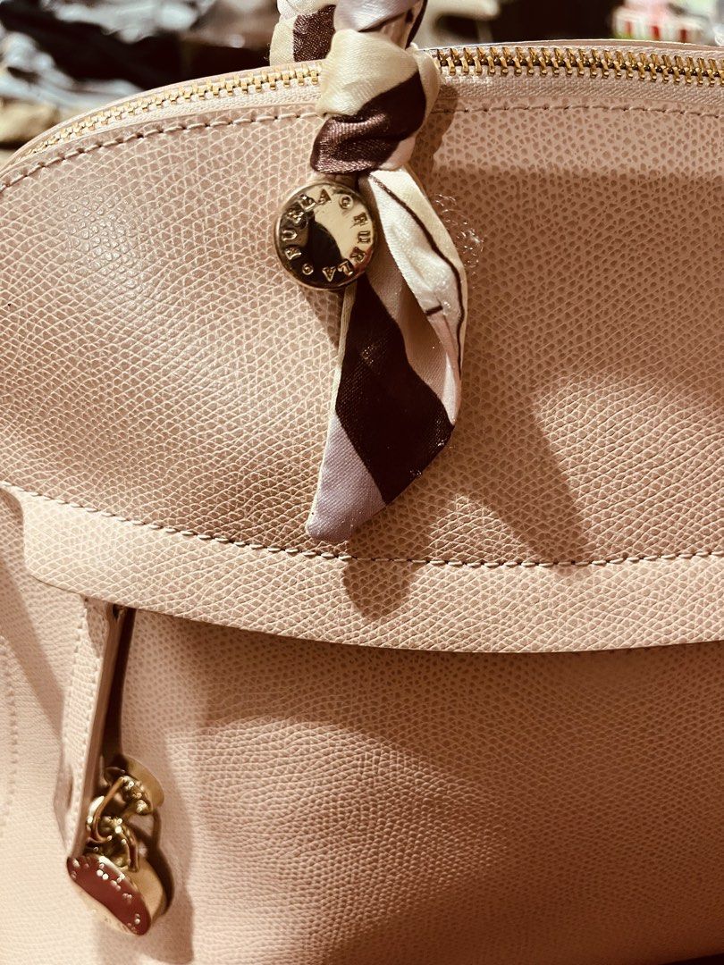 Furla Leather Handbag (Category: Luxury Bags & Wallets) located in Marikina City. Submitted by sakura_07 (Listing ID 1468125420, Image 3). Description: - Brand: Furla (100% Authentic) - Material: Premium pebbled leather - Color: Soft blush pink with gold-tone hardware - Style: Structured dome silhouette with zip closure - Design Details: Includes a stylish brown/cream and a matching front charm - Interior: Lined in pink fabric with 'Genuine Leath