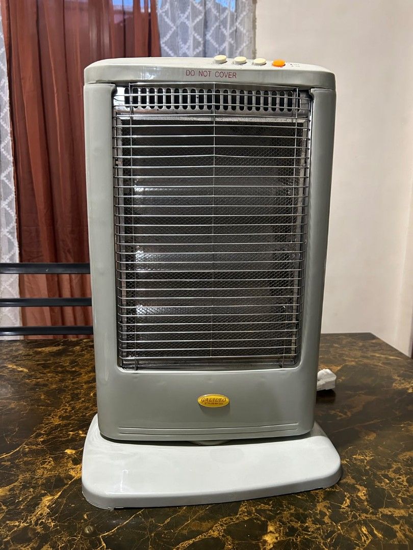 Galileo electric heater (Category: Electrical, Adaptors & Sockets) located in Taguig. Submitted by lhadychinitah (Listing ID 1468255686, Image 3). Description: Type: Halogen Infrared Heater. Power Output: 1200W. Controls: Three buttons on top likely for heat settings. Safety Features: Includes a protective front grill and rotary controls for adjustable heating..