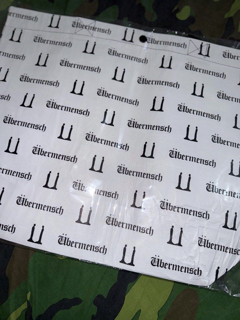 G-DRAGON UBERMENSCH Reusable Bag (Category: Music Accessories) located in Manila. Submitted by trumanblack1975 (Listing ID 1468177808, Image 1). Description: - G-DRAGON UBERMENSCH Reusable Bag (Version 2) - Color: White body with black all-over text print and black handles - Material: Sustainable r-pet polyester - Dimensions: 520 x 400 x 200 mm - Condition: Brand new, still sealed in original plastic packaging - Authenticity: Comes with official 