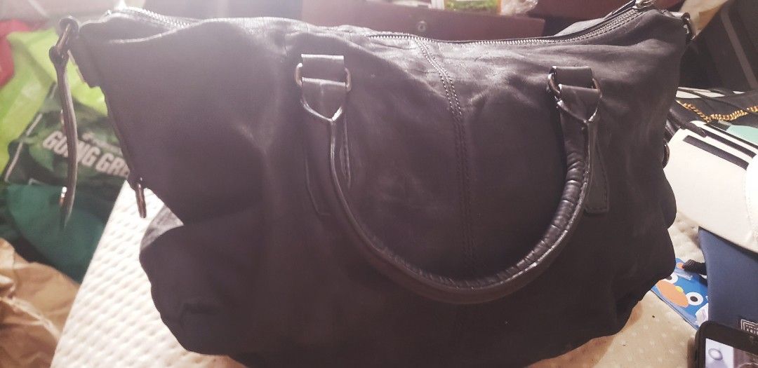 Givenchy Black Leather Handbag (Category: Luxury Bags & Wallets) located in Marikina City. Submitted by racoon143 (Listing ID 1468104626, Image 1). Description: Black leather handbag with top handles and Givenchy 4G logo hardware on the side strap details. Zip top closure across the main compartment. Soft textured leather finish with silver-toned hardware rings. Roomy everyday shoulder bag style..