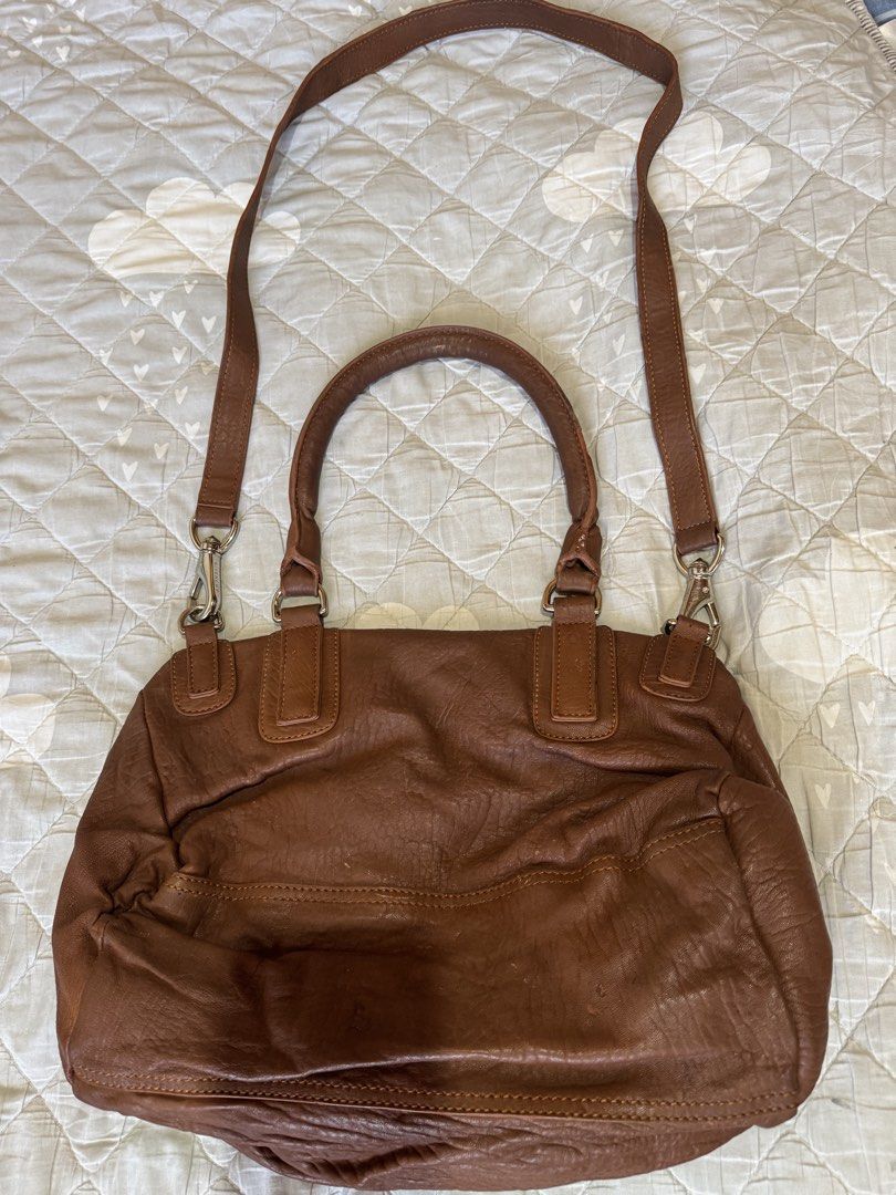Givenchy Brown Leather Pandora Bag (Category: Luxury Bags & Wallets) located in Danao, Cebu. Submitted by jojie.1983 (Listing ID 1468104131, Image 3). Description: - Medium Size Givenchy Pandora bag in classic brown leather - Features a convenient front zipped pocket - Versatile carrying options with double top handles and an adjustable, detachable shoulder strap - Light fabric interior lining complete with Givenchy leather logo tag - Crafted in 