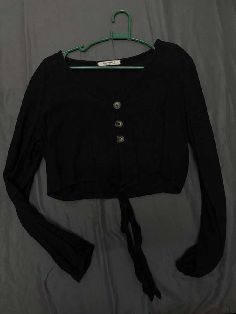 Glamorous Black Long Sleeve Button Front Crop Top (Category: Longsleeves) located in San Fernando. Submitted by gigikyla (Listing ID 1468060746, Image 1). Description: - Brand: Glamorous - Style: Black long sleeve crop top with V-neck, 3 front buttons, and hem tie detail - Material: Comfortable ribbed fabric - Size: UK 10 - Condition: Excellent, clean, no damage or stains - Perfect basic for layering or pairing with high-waisted denim.