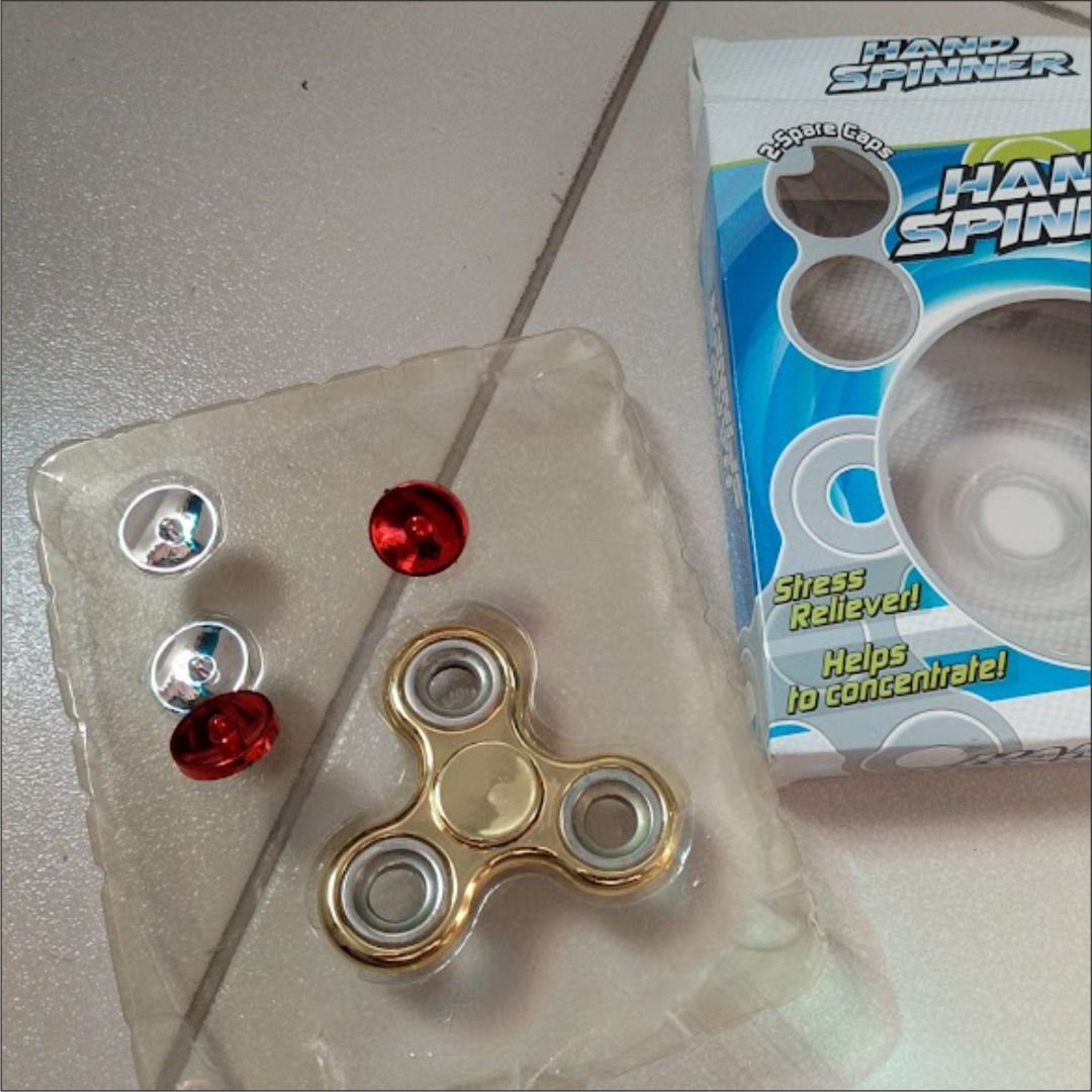 Gold Hand Spinner Fidget Toy with Extra Caps (Category: Action & Battle Toys) located in Quezon City. Submitted by susmaryosep1 (Listing ID 1468190061, Image 2). Description: - Shiny gold hand spinner - Great for stress relief and keeping hands busy - Includes bonus replacement caps in red and silver - Comes in original packaging box with a secure clear plastic tray - Fun desk toy and focus aid 200.