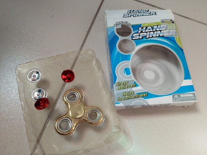Gold Hand Spinner Fidget Toy with Extra Caps (Category: Action & Battle Toys) located in Quezon City. Submitted by susmaryosep1 (Listing ID 1468190061, Image 3). Description: - Shiny gold hand spinner - Great for stress relief and keeping hands busy - Includes bonus replacement caps in red and silver - Comes in original packaging box with a secure clear plastic tray - Fun desk toy and focus aid 200.