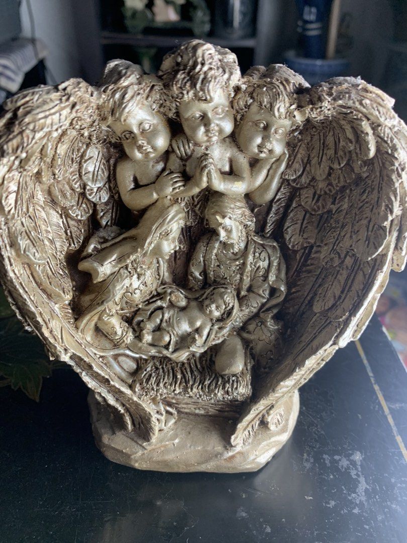 Gold Nativity Scene Figurine with Angels (Category: Figurines & Statues) located in Quezon City. Submitted by sojisup (Listing ID 1468068188, Image 2). Description: - Gold-toned nativity scene figurine - Features Mary, Joseph, and baby Jesus - Surrounded by three cherub angels with detailed wing carvings - Stands on a solid base with a back support stand.