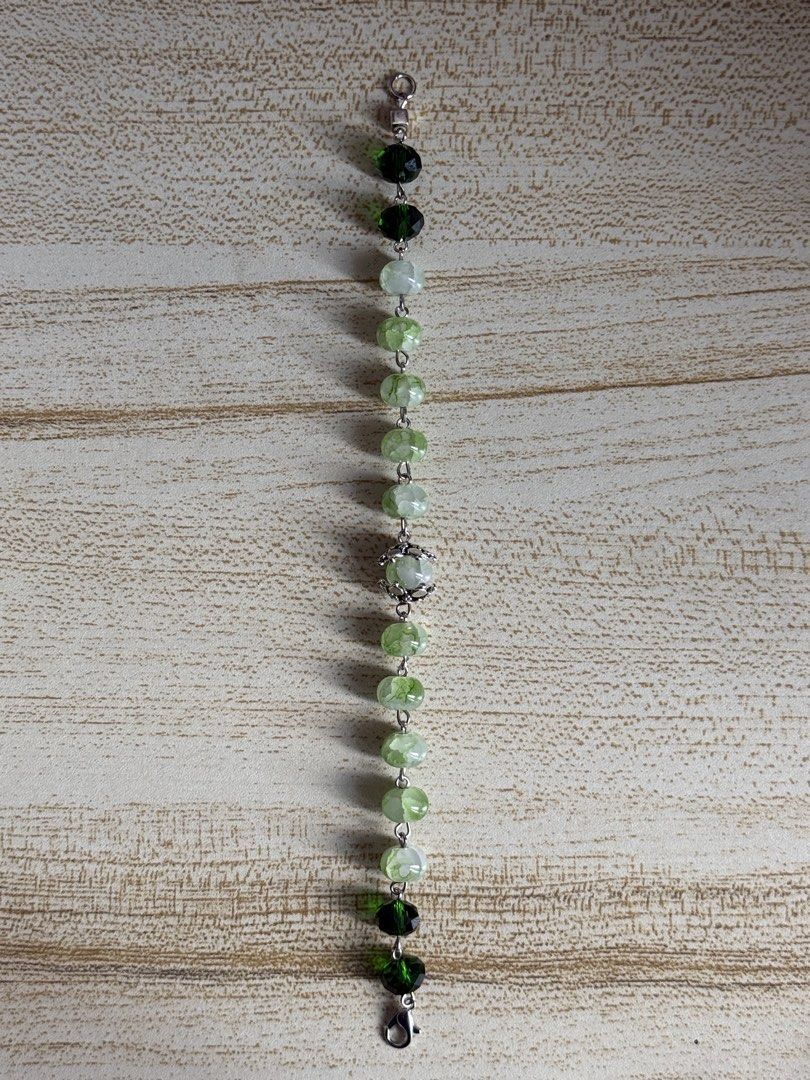 Green Glass Beaded Bracelet (Category: Bracelets) located in Las Pinas. Submitted by yviestments (Listing ID 1468196658, Image 3). Description: -Green crystal bracelet features dark green beads and lighter crackle stone beads. -Silver-tone chain link design with a lobster clasp closure. - Includes a free clear floating frame display case for safe storage and display 📏 BRACELET SIZE GUIDE Find your perfect fit! ✨ Choose the size that feels most c