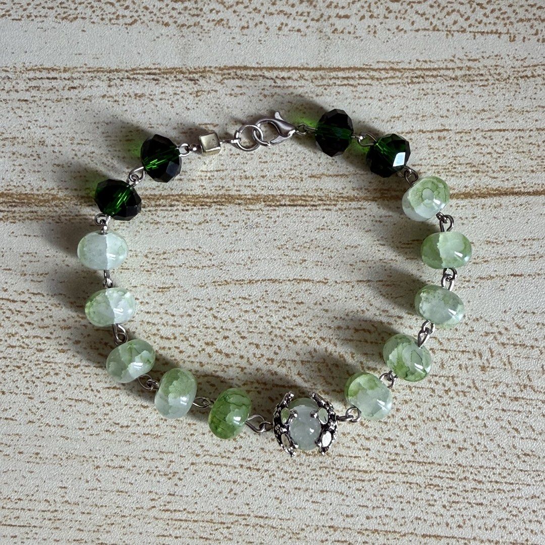 Green Glass Beaded Bracelet (Category: Bracelets) located in Las Pinas. Submitted by yviestments (Listing ID 1468196658, Image 1). Description: -Green crystal bracelet features dark green beads and lighter crackle stone beads. -Silver-tone chain link design with a lobster clasp closure. - Includes a free clear floating frame display case for safe storage and display 📏 BRACELET SIZE GUIDE Find your perfect fit! ✨ Choose the size that feels most c