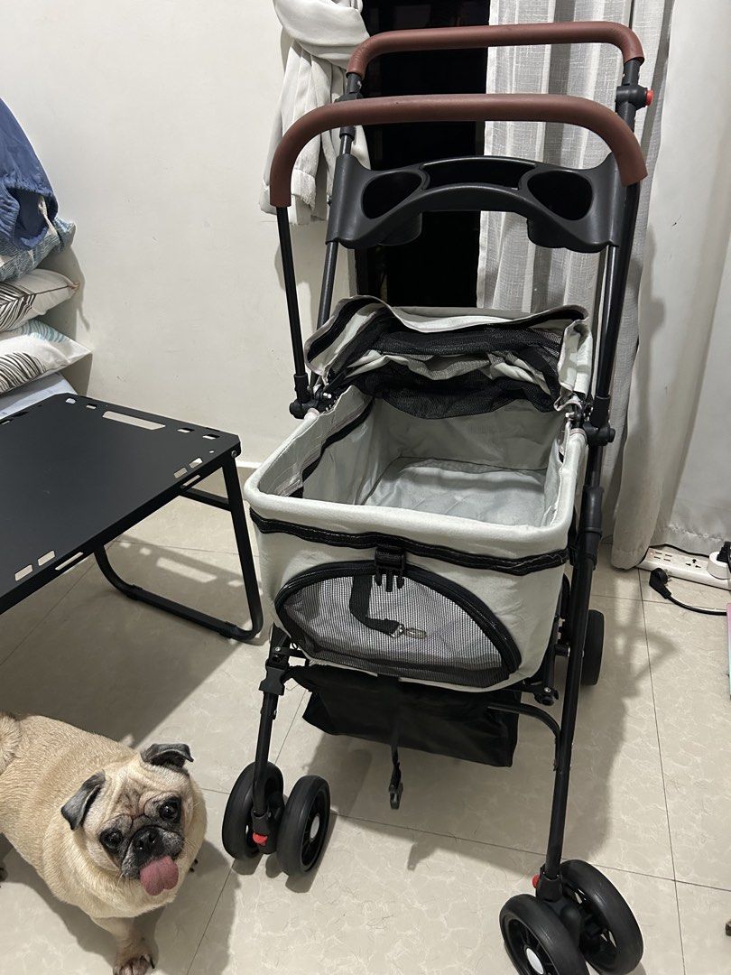 Grey Foldable Pet Stroller with Cup Holder and Storage (Category: Strollers) located in Mandaluyong City. Submitted by ncooooooo (Listing ID 1468224261, Image 1). Description: RFS: Changed to a bigger cart. Naka tambak lang but no issues aside from the foam cracks on the carrier bar due to sun exposure. Minimal wear, visible on the wheels. Already washed the liner. - Color: Grey - Condition: Good working condition, minor surface cracking and wear