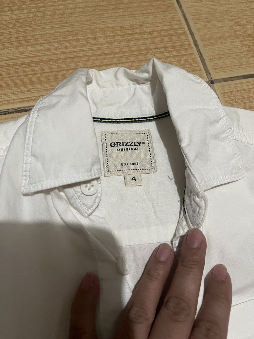Grizzly Original White Long Sleeve Button Down Shirt (Category: Babies & Kids Fashion) located in Quezon City. Submitted by lovedbykarlaa (Listing ID 1468070485, Image 2). Description: - Brand: Grizzly Original - Color: Clean White - Size: 4 - Style: Long sleeve button-down shirt with classic collar - Features: Front pocket and front button closures - Versatility: Perfect for dressing up or smart casual outfits.