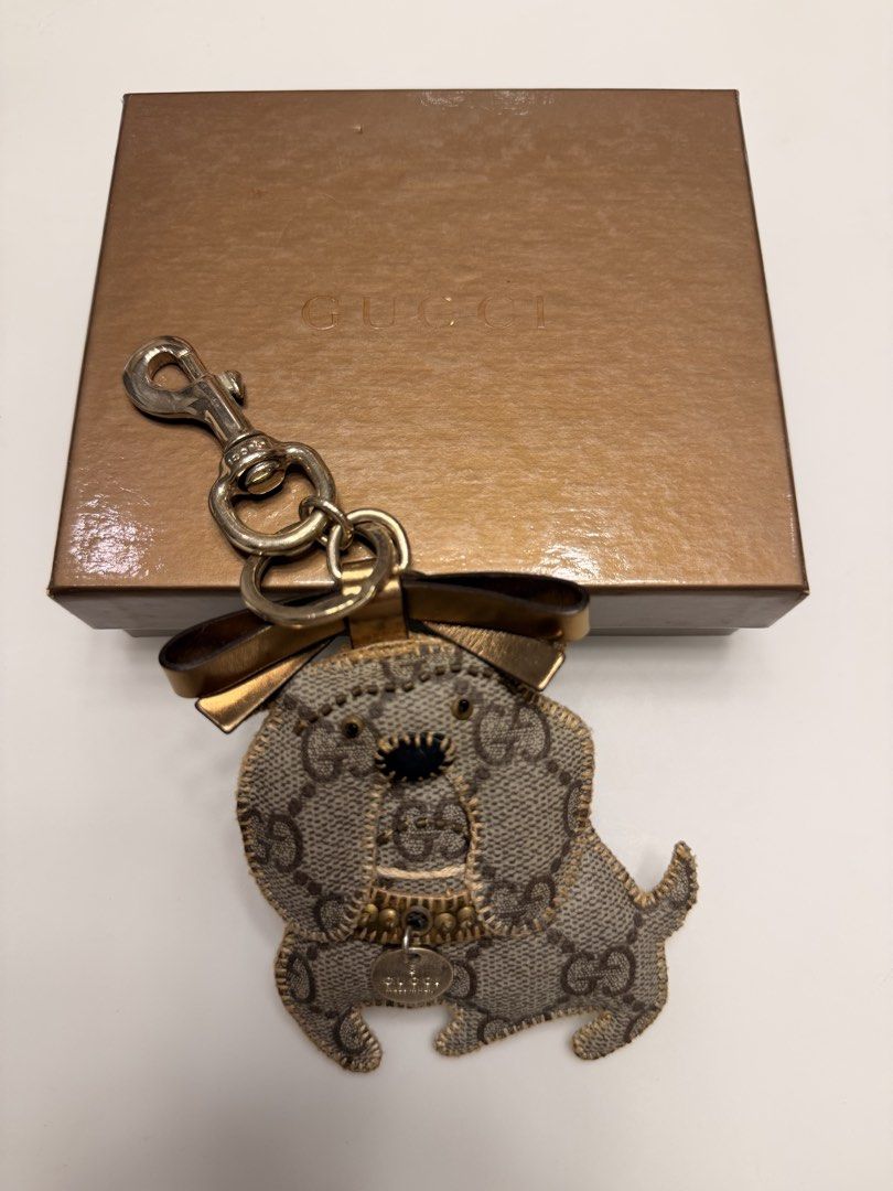 Gucci Dog Keychain Charm with Box (Category: Charms) located in Manila. Submitted by shopbureau (Listing ID 1468096163, Image 1). Description: - Authentic Gucci dog keychain charm with iconic GG monogram canvas - Features premium gold-tone hardware, a secure lobster clasp, and a sturdy key ring - Adorned with a charming little bow detail on top - Comes complete with a branded gold gift box, perfect for gifting - Stylish and fun accessory to eleva