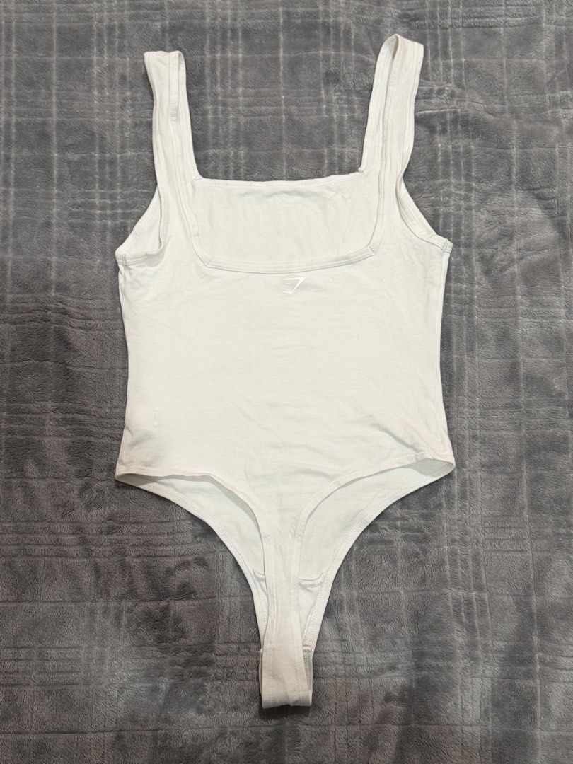 Gymshark White Square Neck Thong Bodysuit Size S (Category: Sleeveless) located in Bulacan. Submitted by richelleregala (Listing ID 1468078685, Image 3). Description: - Brand: Gymshark - Style: Square neck bodysuit - Color: White - Size: S - Material: 95% cotton, 5% elastane (soft stretch fabric) - Details: Thong cut, snap button closure, small silver heat-sealed logo near neckline.
