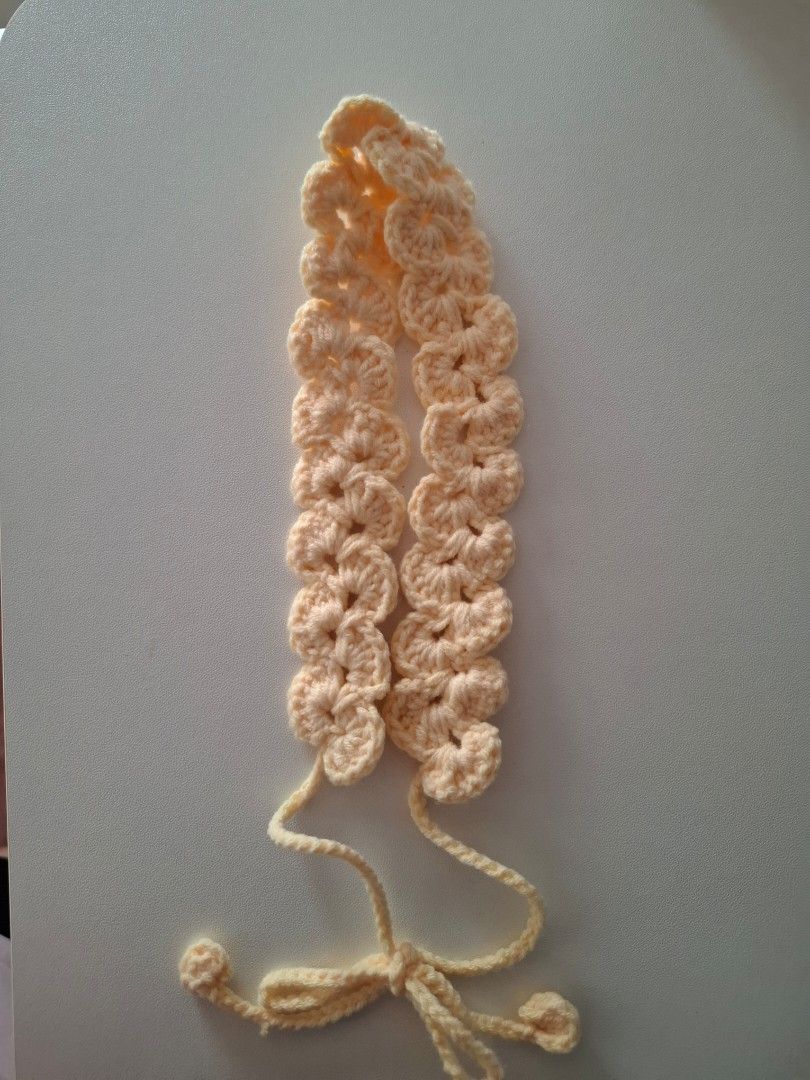 Handmade crochet headband with tie straps (Category: Hair Accessories) located in Cavite. Submitted by sheeeki_ (Listing ID 1468093534, Image 2). Description: - Made to order - Yarn color options: light blue, coffee brown, light pink, light yellow, cream, - Material: Soft yarn texture - Design: Scalloped pattern with adjustable tie-back straps and pompom ends - Style: Handmade crochet, ideal for everyday casual wear - Buyer covers the SF through 