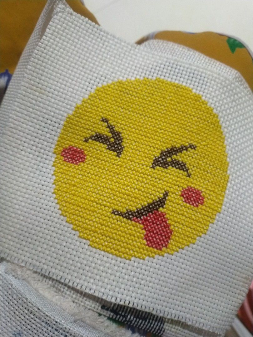 Handmade Emoji Cross Stitch Art (Category: Handmade Craft) located in Pagadian. Submitted by kimygo (Listing ID 1468158048, Image 1). Description: - Handmade winking emoji cross stitch design - Features a bright yellow background circle on white grid fabric - Clean and neat stitching throughout - Perfect for craft lovers or cute room decor - Unfinished edges, ready for framing or trimming.