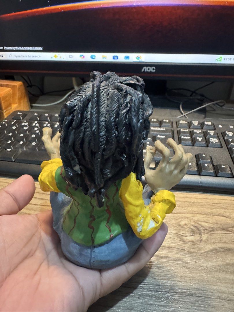 Handmade Hippie Man Figurine with Dreadlocks (Category: Figurines & Statues) located in Cavite. Submitted by marcuz1316 (Listing ID 1468206902, Image 2). Description: Quirky handmade figurine sitting cross-legged. Long black dreadlocks, yellow long-sleeve shirt, green vest, and blue jeans with a patch on the knee. Wearing red flip-flops and a pendant necklace. Detailed facial features including a mustache and beard. Palm-sized decorative piece. M