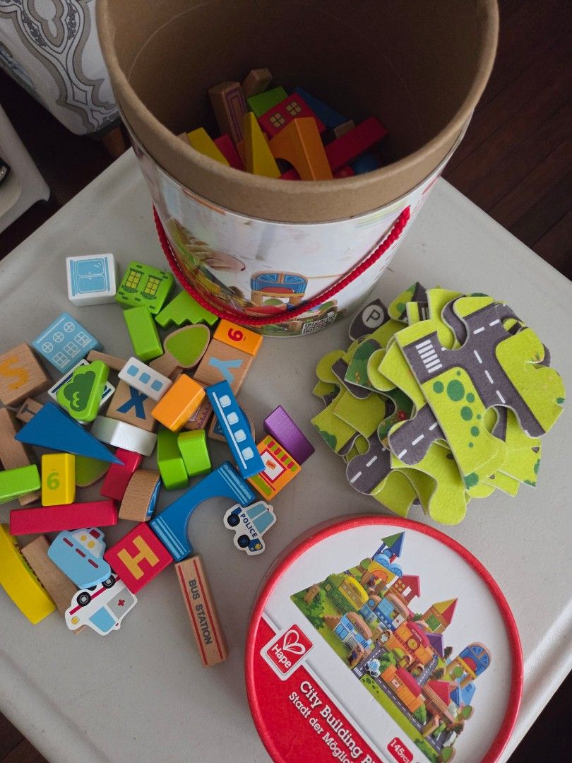 Hape City Building Blocks Set with Puzzle Playmat (Category: Educational & Learning Toys) located in Quezon City. Submitted by robin.t (Listing ID 1468090793, Image 3). Description: - Brand: Hape City Building Blocks - Includes colorful wooden blocks for building towns, hospitals, schools, and police stations - Comes with puzzle playmat pieces to create fun road and city layouts - Encourages imaginative play and creativity for kids - Packed in a 