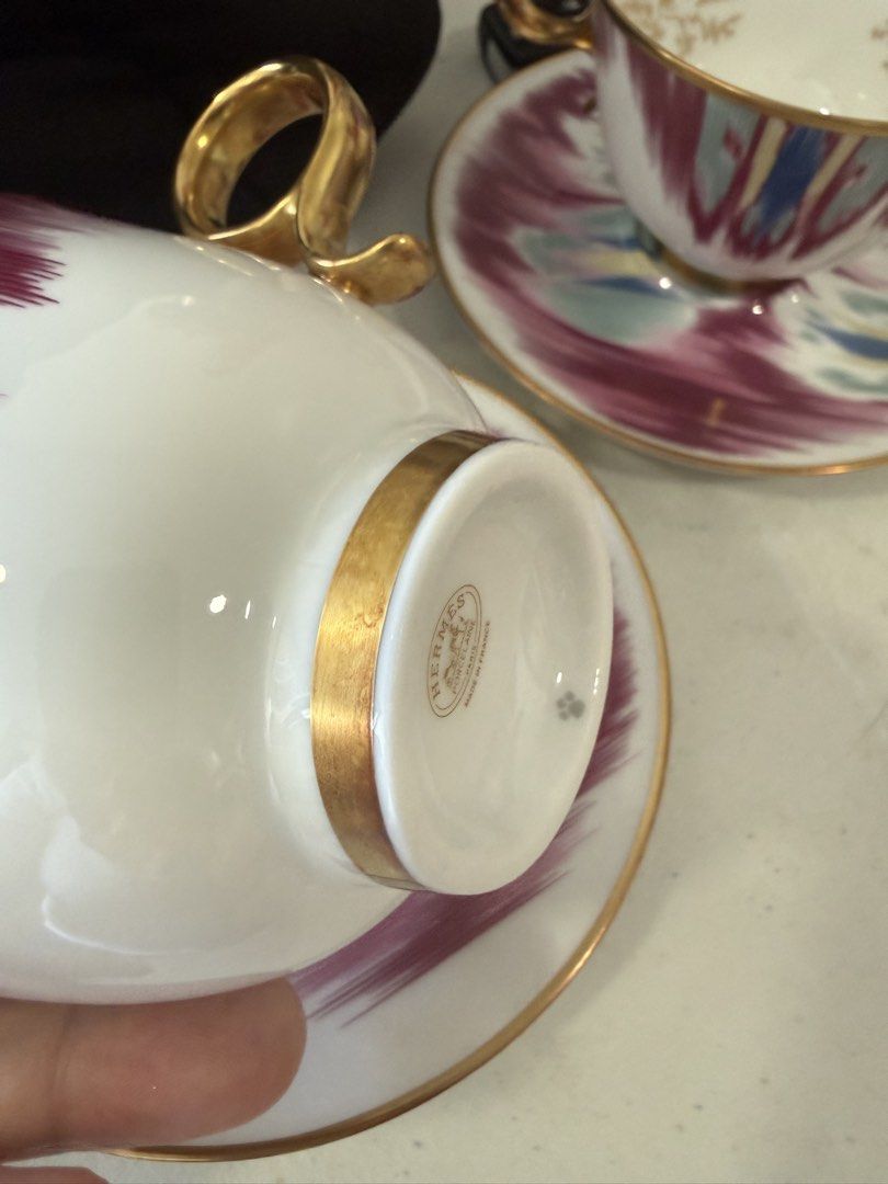 Hermes Ikat Teacups set (Category: Coffee & Tea Tableware) located in Makati City. Submitted by dgcurated09 (Listing ID 1468222070, Image 3). Description: - Unused No box SRP 56k Authentic Hermès tea cup and saucer set, made in France - Stunning abstract brushstroke pattern in purple, blue, and green - Luxurious hand-painted gold trim on rims and ring handles - Features the official Hermes Paris hallmark stamp on the bottom - Matching pair availa