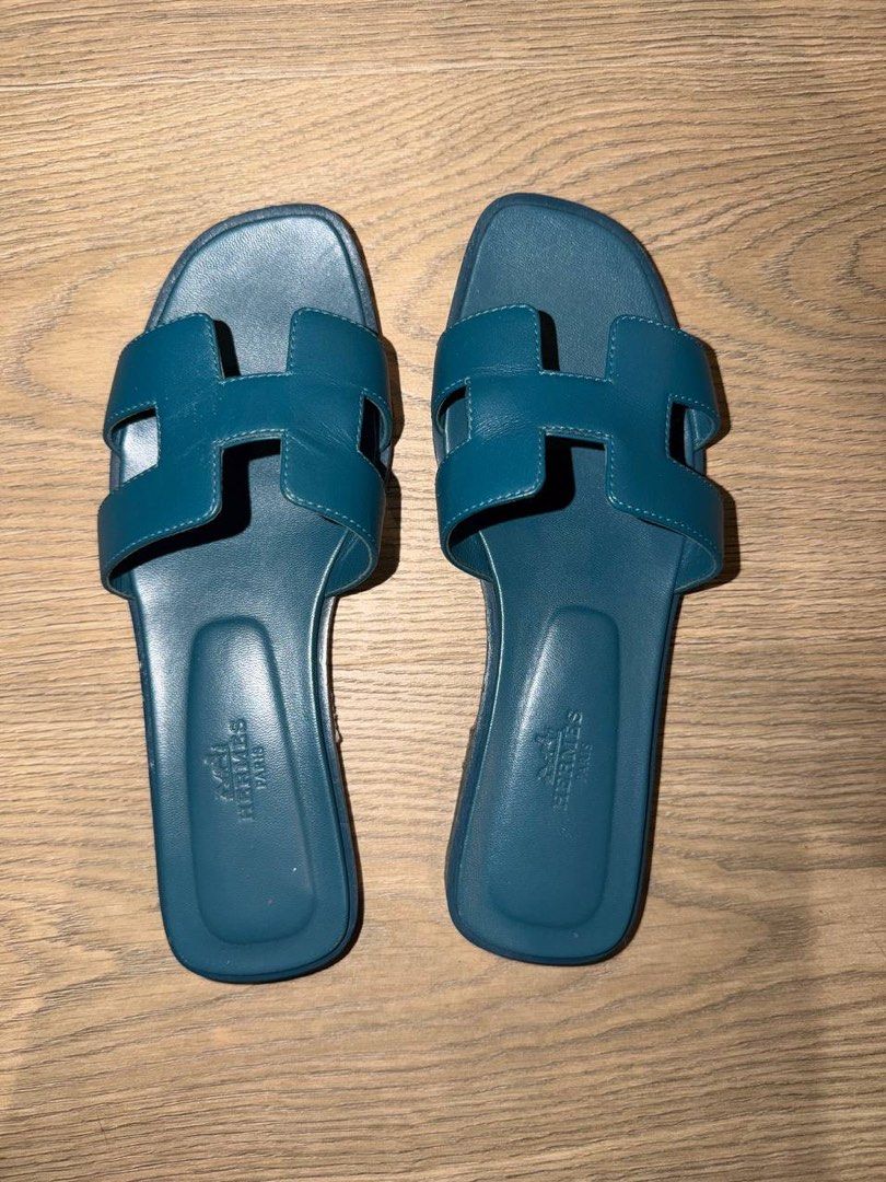 Hermes Oran Sandals Blue Size 36 (Category: Sneakers & Footwear) located in Manila. Submitted by carolinegaweco (Listing ID 1468154448, Image 1). Description: - Brand: Hermes - Style: Oran Sandals - Color: Teal Blue - Size: 36 - Condition: Excellent, clean insoles with clear hot stamp, soles show only very light wear from indoor try-ons - Features: Classic H-cutout strap, easy slip-on design - Perfect for stylish summer wear and everyday luxury.
