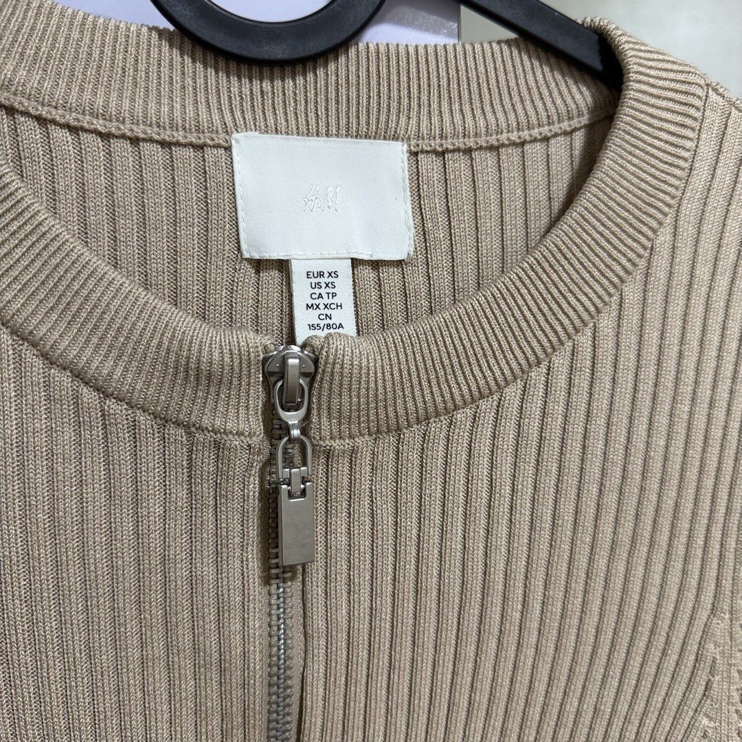 h&m beige ribbed zip-up knit top (Category: Longsleeves) located in Cavite. Submitted by lovedbysham (Listing ID 1468273813, Image 3). Description: - Brand: H&M - Color: Classic beige - Size: EUR XS / US XS / CN 155/80A - Style: Long sleeves, round neckline, half-zip front with silver pull tab - Fit: Fitted silhouette, cropped length - Material: Soft ribbed knit with plenty of stretch.