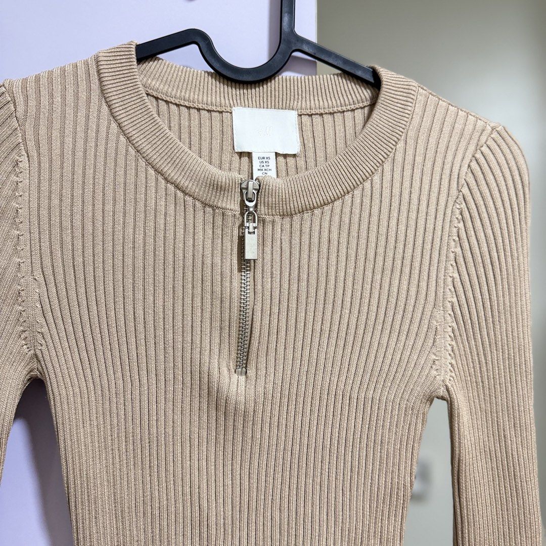 h&m beige ribbed zip-up knit top (Category: Longsleeves) located in Cavite. Submitted by lovedbysham (Listing ID 1468273813, Image 2). Description: - Brand: H&M - Color: Classic beige - Size: EUR XS / US XS / CN 155/80A - Style: Long sleeves, round neckline, half-zip front with silver pull tab - Fit: Fitted silhouette, cropped length - Material: Soft ribbed knit with plenty of stretch.