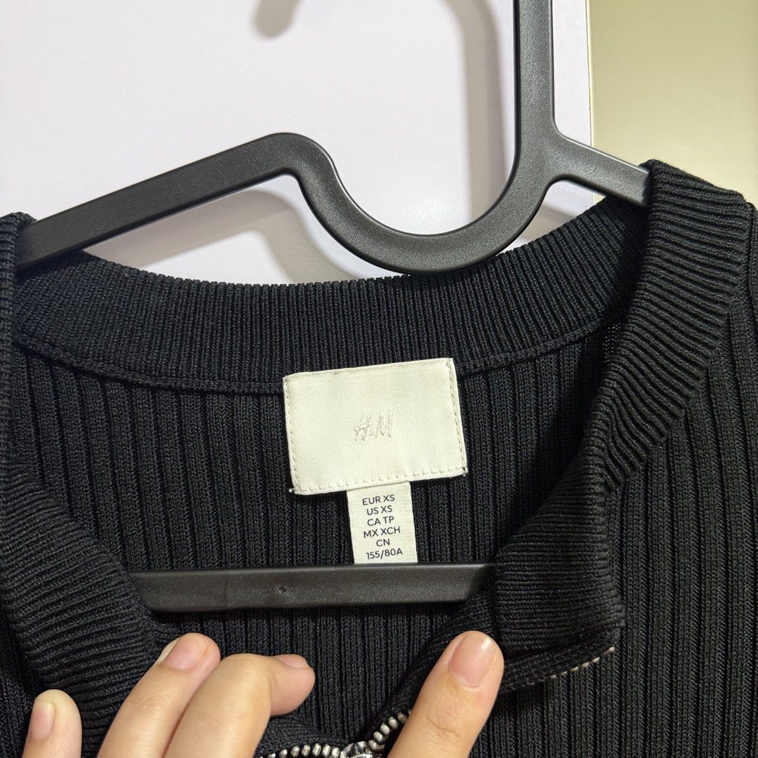 h&m black ribbed zip-up knit top (Category: Longsleeves) located in Cavite. Submitted by lovedbysham (Listing ID 1468273548, Image 3). Description: - Brand: H&M - Color: Black - Size: XS - Material: Stretchy ribbed knit - Features: Front half-zip with silver pull tab, round neckline, long sleeves, cropped fit - Condition: Worn a few times, great shape - Style Tip: Perfect to match with high-waisted jeans or skirts.
