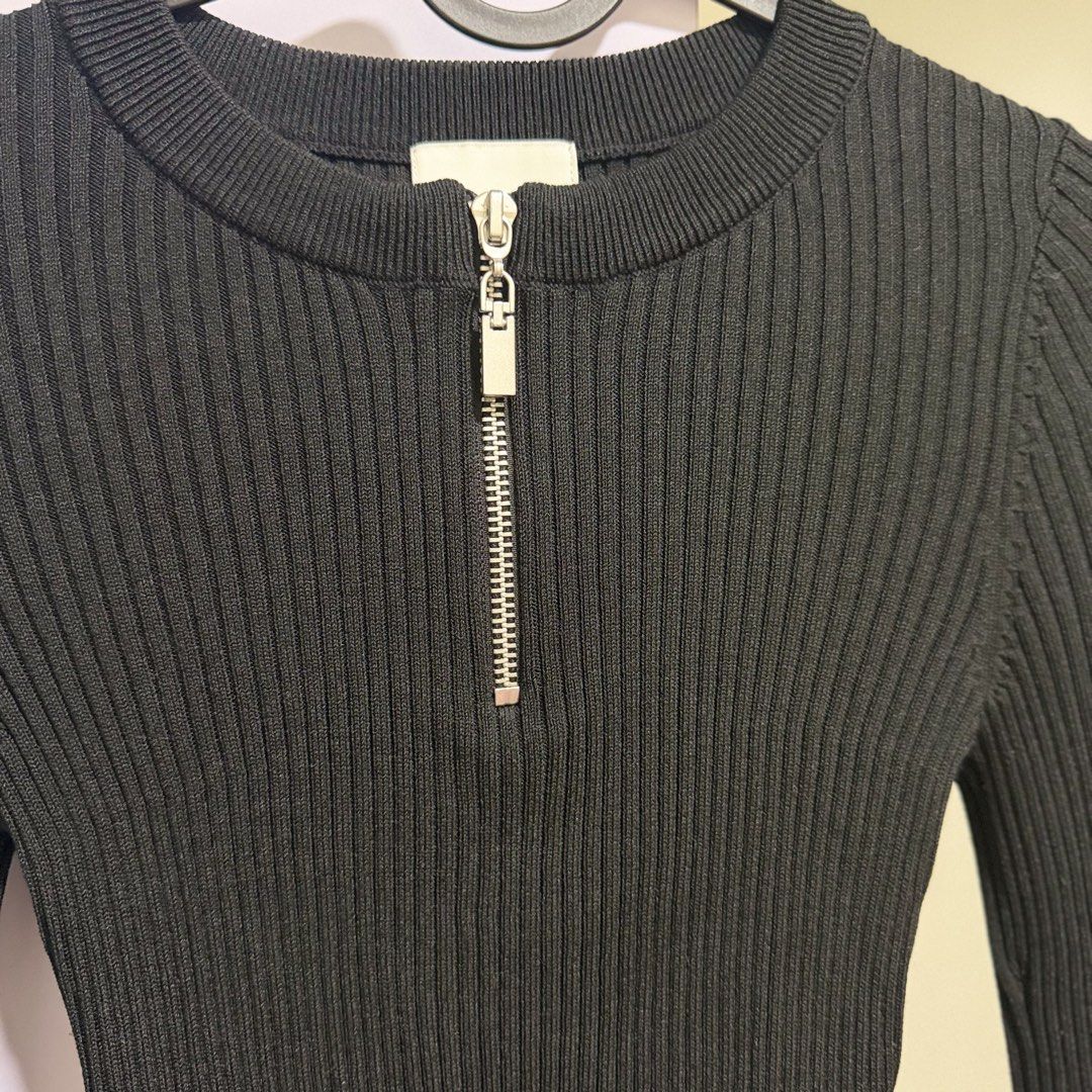h&m black ribbed zip-up knit top (Category: Longsleeves) located in Cavite. Submitted by lovedbysham (Listing ID 1468273548, Image 2). Description: - Brand: H&M - Color: Black - Size: XS - Material: Stretchy ribbed knit - Features: Front half-zip with silver pull tab, round neckline, long sleeves, cropped fit - Condition: Worn a few times, great shape - Style Tip: Perfect to match with high-waisted jeans or skirts.