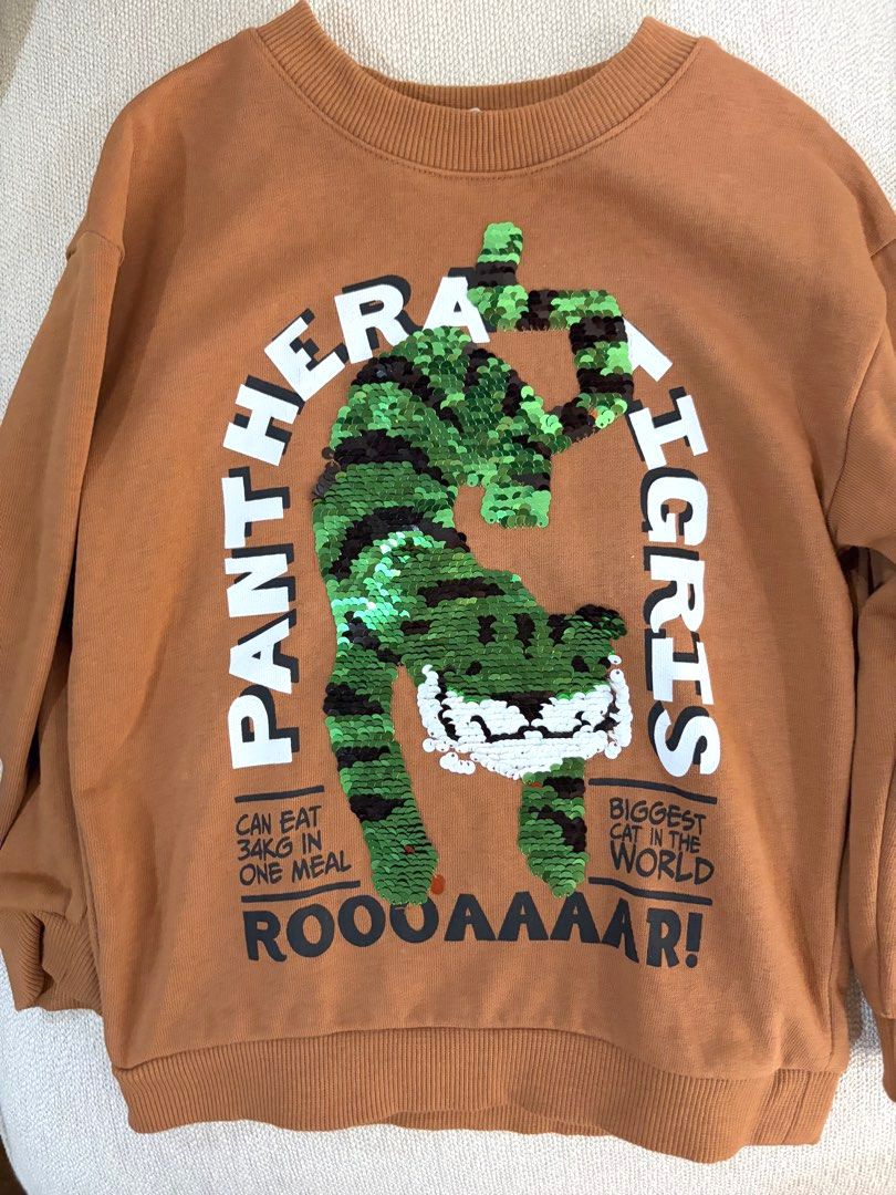 H&M Tiger Reversible Sequin Sweatshirt Size 3-4Y (Category: Babies & Kids Fashion) located in Quezon City. Submitted by rchantong (Listing ID 1468127471, Image 2). Description: - Brand: H&M - Size: EUR 104, US 4T (3-4 years) - Color: Brown - Fun reversible sequin tiger graphic (flips between orange and green) - Features 'Panthera Tigris' and 'Roooaaaar!' text graphics - Warm fleece lining for extra comfort - Ribbed crew neckline, cuffs, and hem.