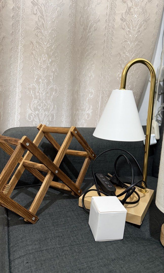 Home Decor Bundle – 2 Lamps + Wooden Wine Rack. (Category: Lighting) located in Manila. Submitted by nessaph (Listing ID 1468173035, Image 3). Description: HOME DECOR BUNDLE FOR SALE 🏡✨ Selling 3 items together: * Gold & White Candle Warmer Lamp – In good condition, well maintained. * Small Bedside Lamp – Used, with visible signs of wear. Features a modern fabric shade, wooden base, and USB-powered connection. * Foldable Wooden Wine Rack – Pract