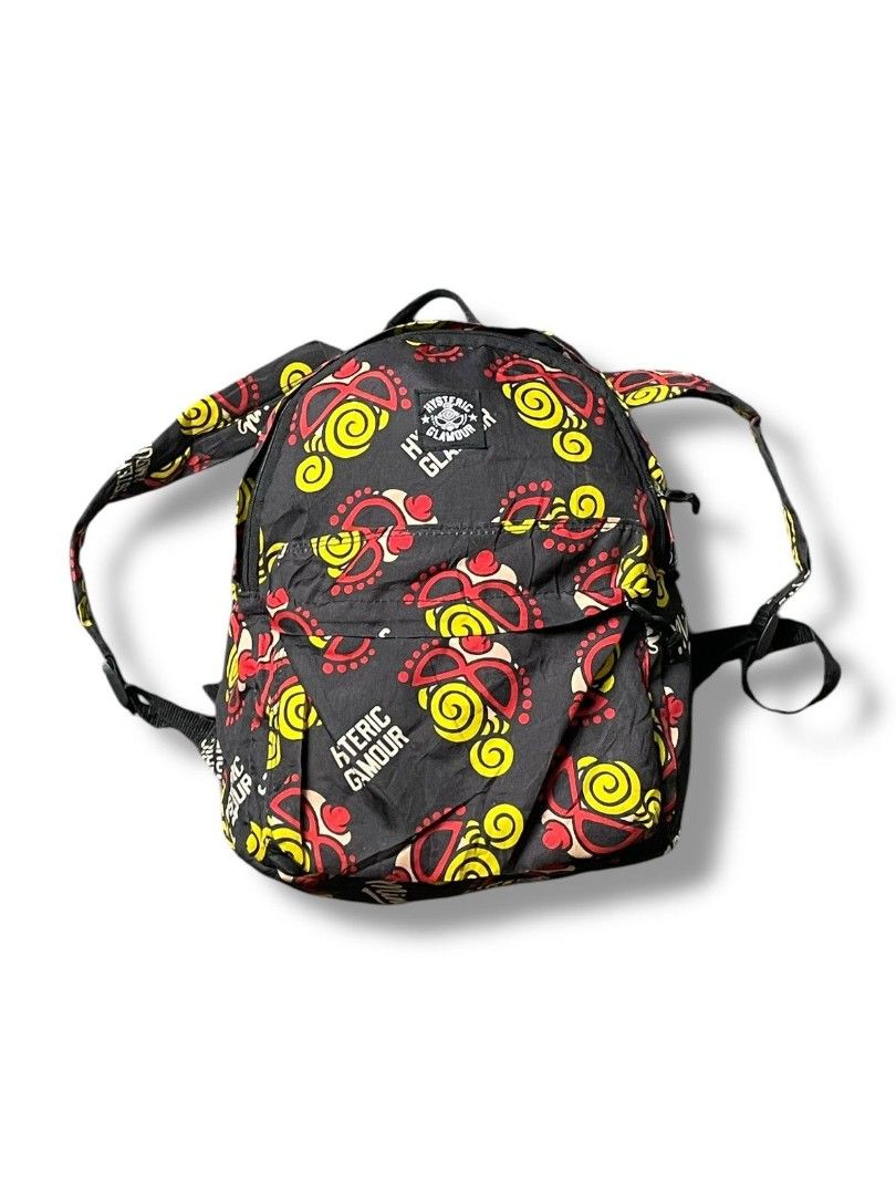 Hysteric Glamour Mini Backpack Black Red Yellow Print (Category: Backpacks) located in Manila. Submitted by ixgri (Listing ID 1468064212, Image 2). Description: - Brand: Hysteric Glamour - Color: Black with vibrant red, yellow, and white graphics - Material: Durable nylon fabric - Features: Iconic circular logo patch, "Mini" and brand typography prints - Compartments: Main compartment and front zipper pocket for extra storage - Straps: Adjustable
