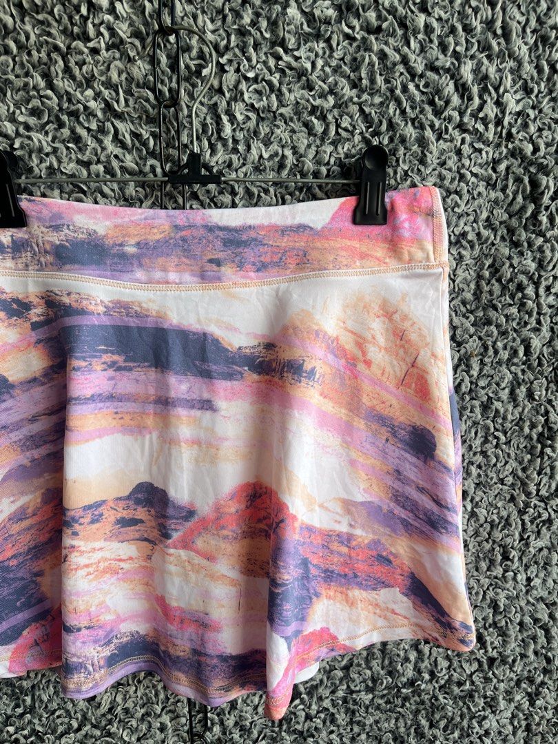 Ideology activewear skort. | Size XL (Category: Skirts) located in General Trias. Submitted by zrchustle.604 (Listing ID 1468281434, Image 2). Description: Ideology activewear skort. It features a colorful, multi-toned landscape print that resembles mountains at sunset, blending shades of pink, purple, orange, and white. Designed for athletic activities like tennis, golf, or running, it includes a wide comfort waistband and built-in liner shorts 