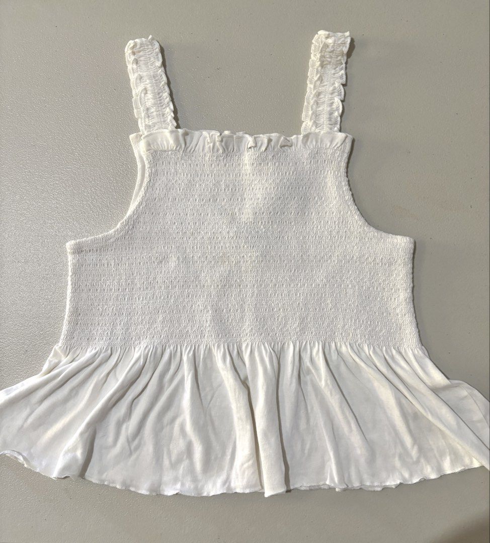 Jeff & Co White Smocked Tank Top (Category: Sleeveless) located in Guimba. Submitted by huenited (Listing ID 1468071540, Image 1). Description: - Brand: Jeff & Co. - Color: White - Condition: Brand new with tags (never worn) - Features: Ruffled straps, stretchy smocked bodice, and flared peplum hem - Perfect basic top for warm weather.