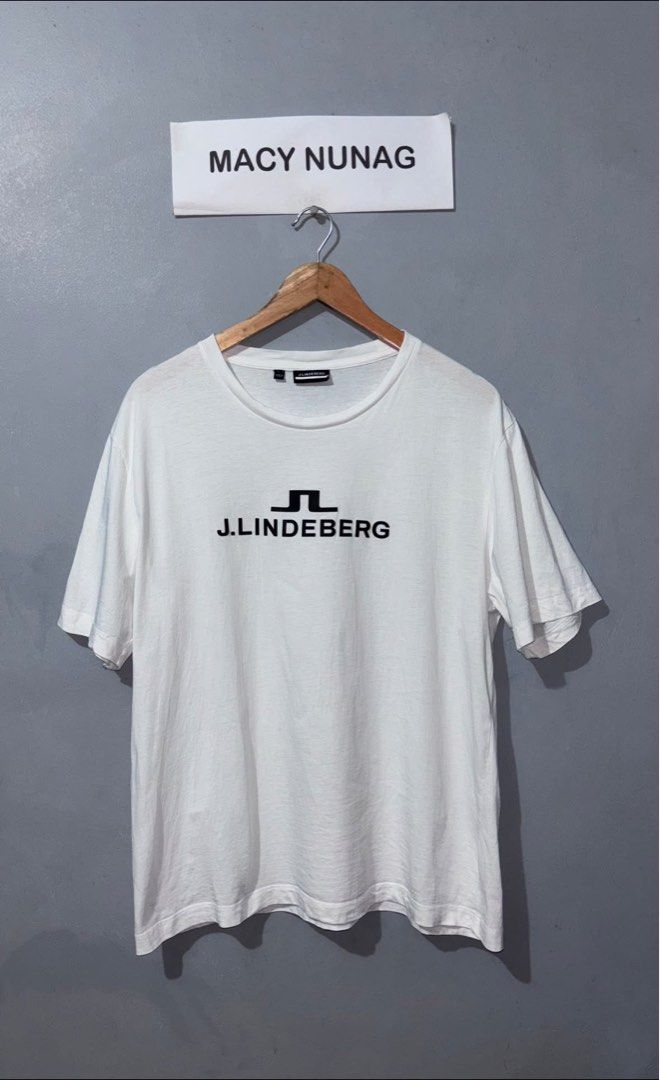j.lindeberg White T-Shirt Size L (Category: Luxury Apparel) located in Cuyapo. Submitted by mn.finds (Listing ID 1468136745, Image 1). Description: - Brand: J.Lindeberg - Color: White with black chest logo print - Size: Large - Style: short sleeves - Origin: Made in China - Condition: Clean fabric overall, with minor fraying .
