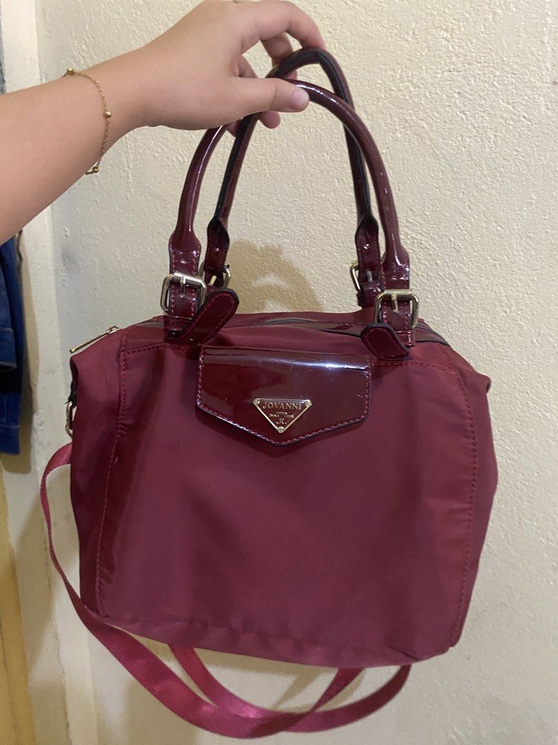 JOVANNI Maroon Handbag (Category: Luxury Bags & Wallets) located in Manila. Submitted by camsvallejos_ (Listing ID 1468088838, Image 1). Description: - Brand/Model: JOVANNI Maroon Shoulder Bag - Style: Daily tote with shiny patent leather handles and front flap detail - Storage: Secure main zipper closure and convenient back zip pocket - Versatility: Includes a removable matching crossbody strap for hands-free wear - Build: Lightweight fabric bod