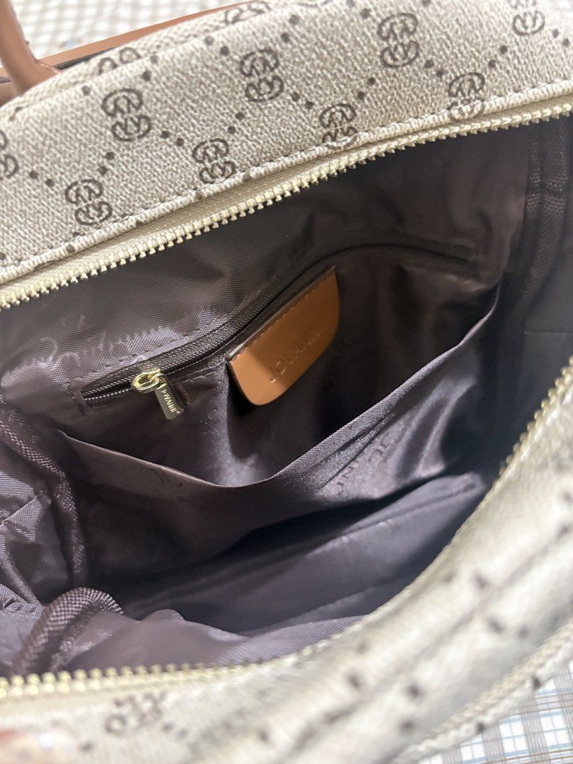 Jovanni monogram print backpack with brown trim (Category: Backpacks) located in Manila. Submitted by lovepeachzz (Listing ID 1468138148, Image 2). Description: - Brand/Style: Jovanni monogram backpack in beige - Accents: Brown leather trim and elegant gold hardware - Pockets: Multiple zipped outer pockets, side pockets, interior zip compartment, and open slip pockets - Interior: Clean brown fabric lining - Comfort & Carry: Adjustable shoulder st