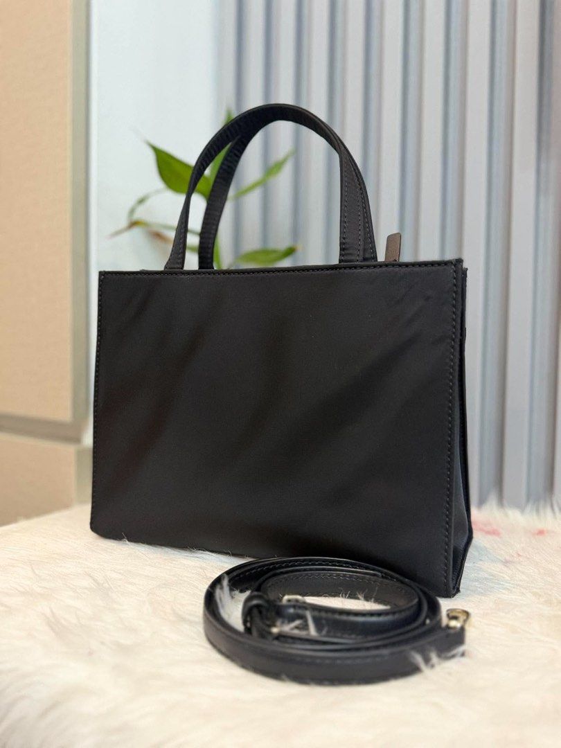 Kate Spade Black Tote Bag with Strap (Category: Tote Bags) located in Manila. Submitted by angel.valle (Listing ID 1468168757, Image 2). Description: - Brand: Kate Spade - Color: Classic Black - Material: Durable nylon with gold hardware lettering - Straps: Double top handles + adjustable, detachable leather strap - Closure: Secure zip-top closure - Base: 4 protective metal feet - Condition: Clean interior and exterior, minor creases from storage