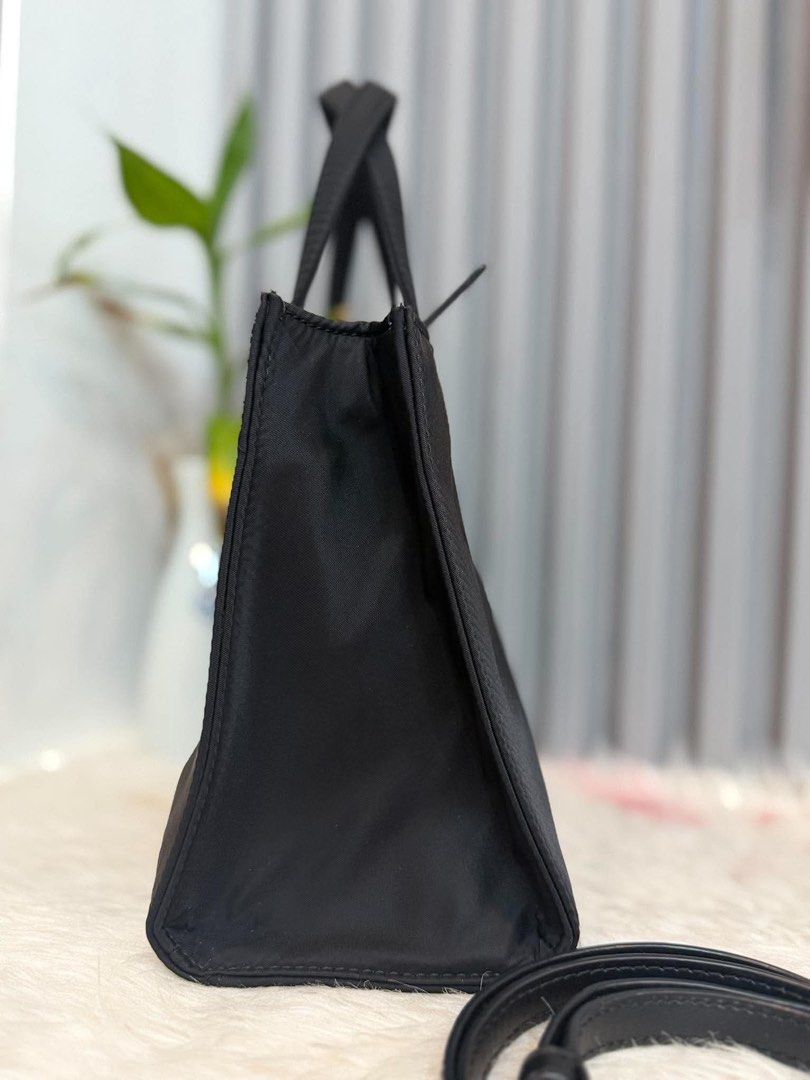 Kate Spade Black Tote Bag with Strap (Category: Tote Bags) located in Manila. Submitted by angel.valle (Listing ID 1468168757, Image 3). Description: - Brand: Kate Spade - Color: Classic Black - Material: Durable nylon with gold hardware lettering - Straps: Double top handles + adjustable, detachable leather strap - Closure: Secure zip-top closure - Base: 4 protective metal feet - Condition: Clean interior and exterior, minor creases from storage