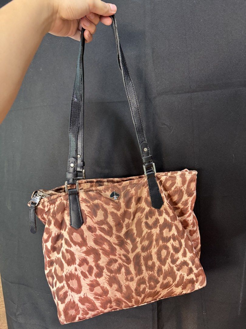 Kate Spade Leopard Print Nylon Tote Bag (Category: Tote Bags) located in Manila. Submitted by meegy (Listing ID 1468111747, Image 1). Description: - Authentic Kate Spade tote bag - Bold brown and tan leopard print fabric with chic black leather shoulder straps - Secure top zipper closure to keep your belongings safe - Spacious interior easily fits daily essentials - Features iconic metal Spade logo hardware .