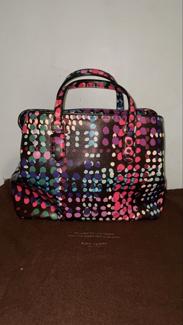 Kate Spade New York Dot Print Handbag (Category: Tote Bags) located in Manila. Submitted by ryoughhthrift (Listing ID 1468094933, Image 3). Description: - Brand: Kate Spade New York - Design: Vibrant multi-color dot pattern on a dark base with elegant gold-tone hardware - Features: Double top handles, structured shape, reinforced base, and a roomy interior for daily essentials - Inclusion: Matching brown dust bag with gold lettering - Condition: 