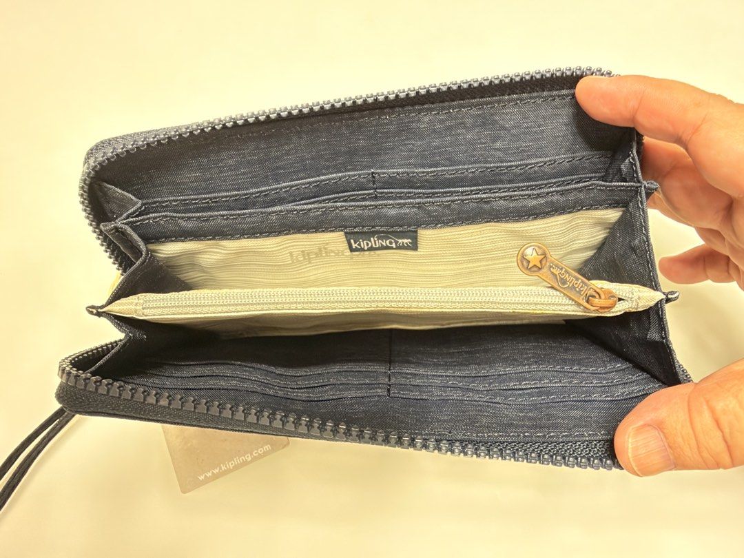 Kipling Alija Wallet Spark Navy (Category: Wallets & Card holders) located in Manila. Submitted by shopbureau (Listing ID 1468096504, Image 3). Description: - Brand: Kipling - Model: Alija Wallet - Color: Spark Navy (denim-like fabric) - Hardware: Rose gold metal Kipling logo - Closure: Zip-around with attached wrist strap - Interior: Multiple card slots, slip compartments, and zippered coin pocket - Condition: Brand new with original retail tag 
