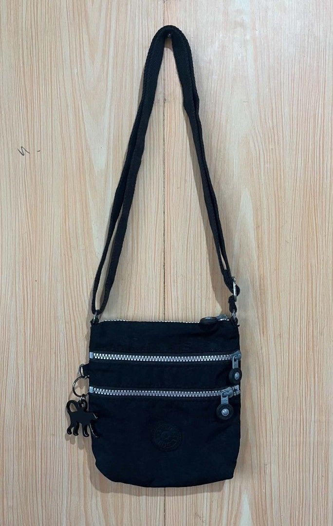 Kipling Black Crossbody Bag K15047-900 (Category: Cross-body Bags) located in Daraga. Submitted by thethriftcity2024 (Listing ID 1468104983, Image 1). Description: - Authentic black Kipling crossbody bag (Model K15047-900) - Crafted from durable, lightweight nylon material - Multiple exterior zippered pockets with signature round pull tags - Long adjustable strap for a comfortable, custom fit - Includes the iconic black monkey keychain - Compact 