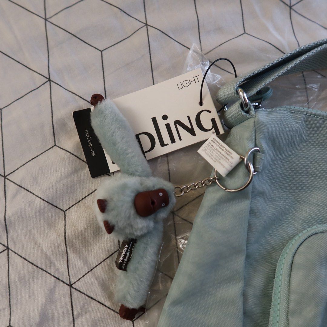 Kipling Sidney Crossbody Bag Springtime Sage (Category: Cross-body Bags) located in Manila. Submitted by gentlewind_62f064 (Listing ID 1468062247, Image 2). Description: - Brand: Kipling - Model: Sidney Crossbody Bag (HB7685 CX1) - Colorway: Springtime Sage - Dimensions: 13.5" x 10" x 6" - Features: Two front zippered compartments and adjustable shoulder strap - Includes: Signature furry monkey keychain named Arianna - Condition: Brand new with o