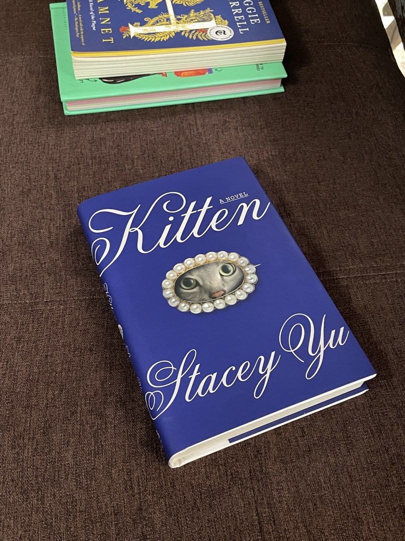 Kitten: A Novel by Stacey Yu Hardcover (Category: Storybooks) located in Malaybalay. Submitted by fundthismaterialgirl (Listing ID 1467605232, Image 1). Description: - Title: Kitten by Stacey Yu - Format: Hardcover Edition SO HARD TO FIND IN THE PHILIPPINES - Design: Beautiful blue cover with pearl-framed cat face artwork - Condition: Excellent condition, bought this September. - Laufey Book Club reco - originally 1,450 on fully booked - RFS: dec