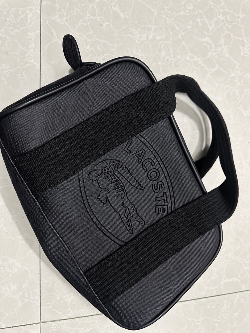 Lacoste Black Crossbody Shoulder Bag (Category: Sling Bags) located in Manila. Submitted by nihn02 (Listing ID 1468116111, Image 1). Description: - Authentic black Lacoste shoulder bag - Durable textured canvas body with structured piping - Large embossed crocodile logo on the front panel - Comfortable thick webbed shoulder strap - Secure zip-top closure with branded zipper pull - Pristine, clean interior and exterior condition.