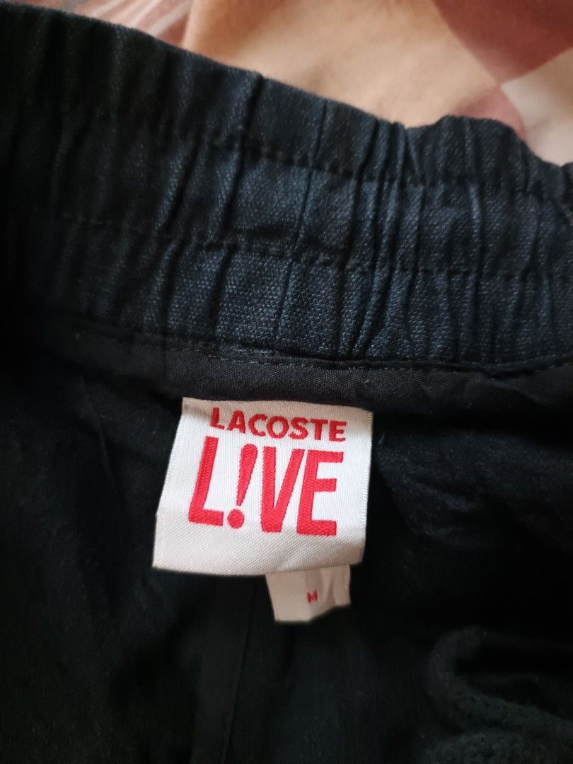 Lacoste Live jogger pants (Category: Activewear) located in Odiongan. Submitted by thriftngo26 (Listing ID 1468064530, Image 2). Description: The image shows a pair of black Lacoste lightweight water-repellent tracksuit pants/joggers featuring an elastic waistband with a drawstring and the iconic Lacoste crocodile logo near the hip.