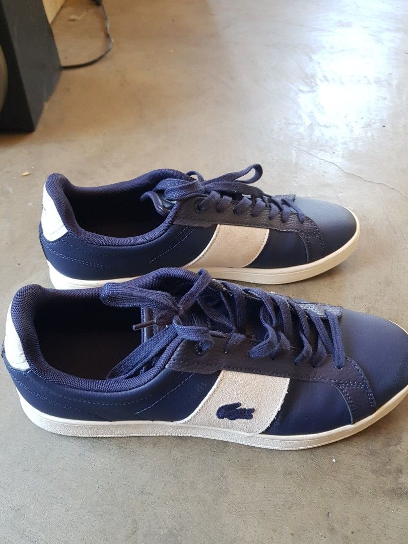 Lacoste Navy Blue Casual Sneakers (Category: Casual Shoes) located in Bayombong. Submitted by eugeneamor58469 (Listing ID 1468098113, Image 3). Description: - Brand: Lacoste - Color: Navy blue with white side stripes and matching blue laces - Material: Textured leather upper with a white rubber sole - Comfort: Padded inner collar -came from canada,reason of selling too long for me,my size is only 10US.