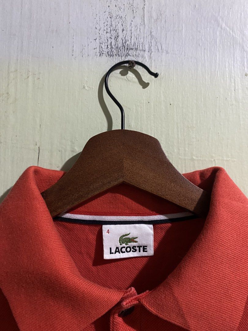 lacoste polo shirt (Category: Tshirts & Polo Shirts ) located in Pandi. Submitted by nasya_thrift_collection2023 (Listing ID 1468233801, Image 2). Description: - Brand: Devanlay - Color: Bright red - Material: Classic piqué fabric texture - Design: Standard button placket and collar - Fit: Comfortable, great for everyday casual wear - Care Instructions: Machine wash warm at 40°C, warm iron at 150°C, do not bleach, do not tumble dry, do not dry cl